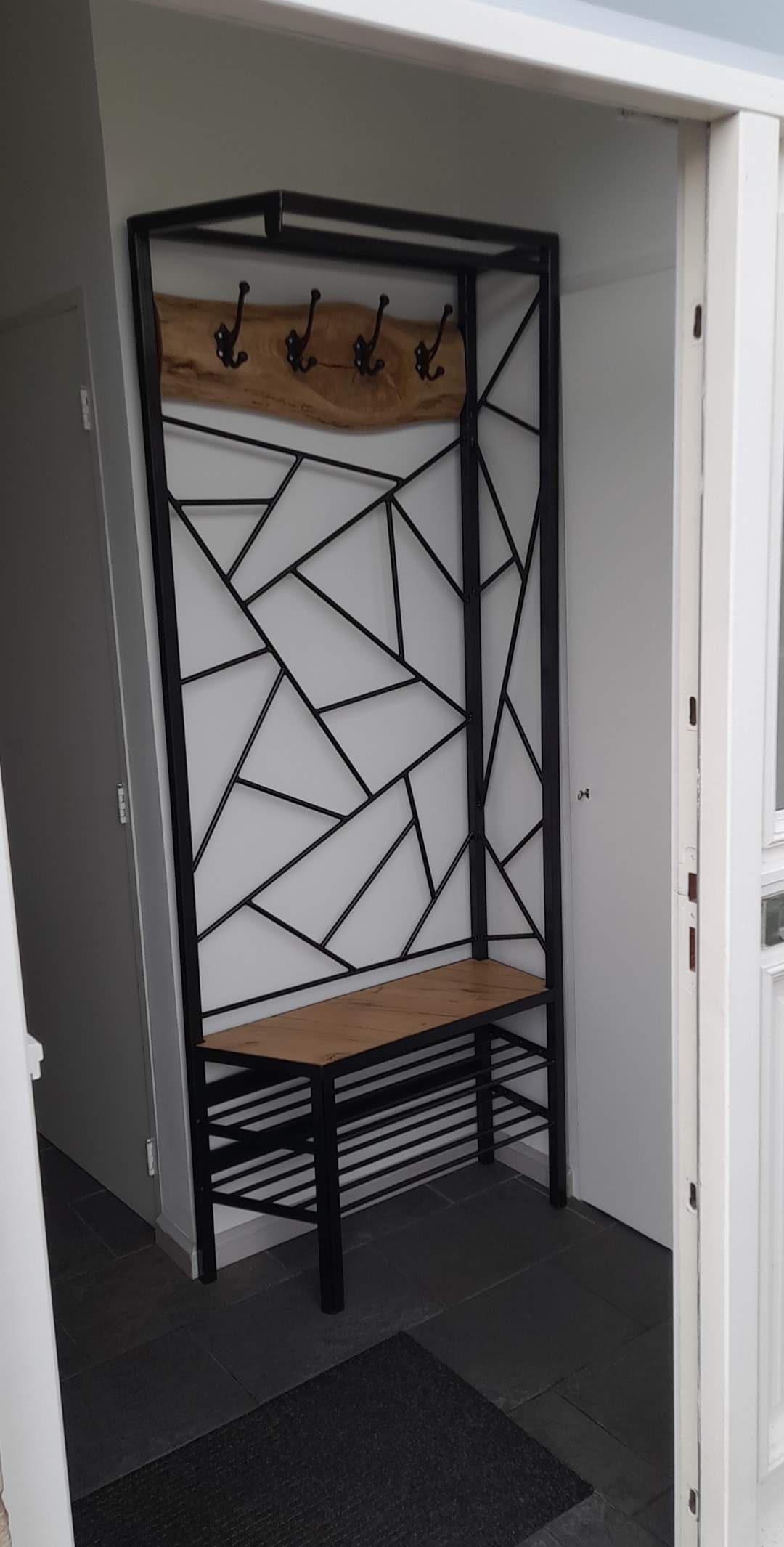 Maatwerk stalen kapstok met geometrisch patroon en houten zitbank